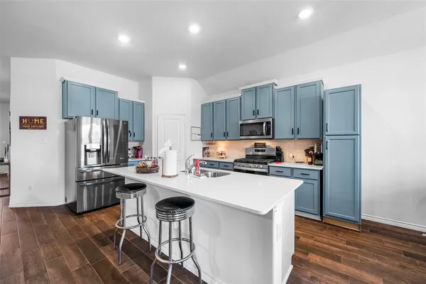 a kitchen with kitchen island a stove a refrigerator and wooden cabinets