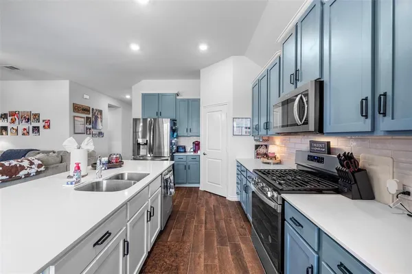 a kitchen with a sink stove top oven and cabinets