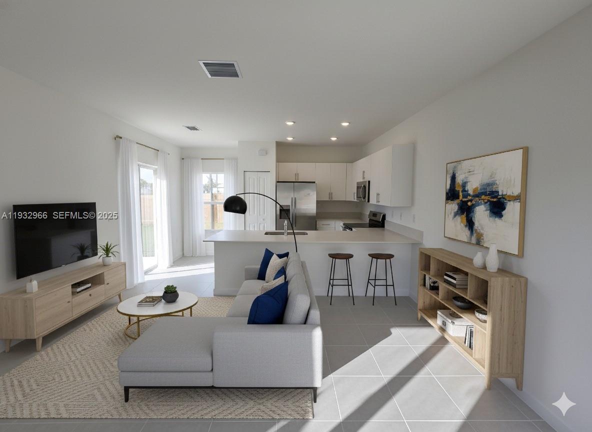 12136 Southwest 268th Street Homestead, FL 33032 - Photo 6 of 11 a living room with furniture a flat screen tv and a refrigerator