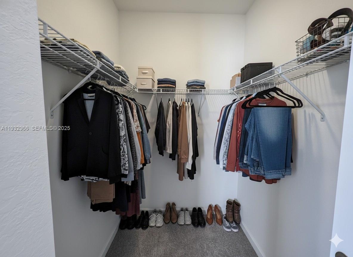 12136 Southwest 268th Street Homestead, FL 33032 - Photo 8 of 11 a view of walk in closet with clothes and shoes