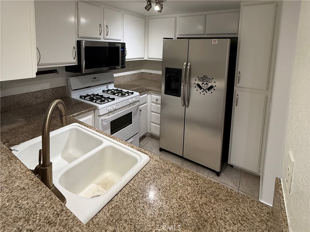 445 Ribbon Beach Way, Unit 278 Oceanside, CA 92058 - Photo 3 of 19 a kitchen with a refrigerator sink and stove