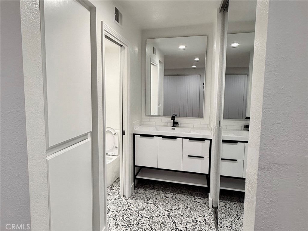 445 Ribbon Beach Way, Unit 278 Oceanside, CA 92058 - Photo 7 of 19 a bathroom with a double vanity sink and mirror