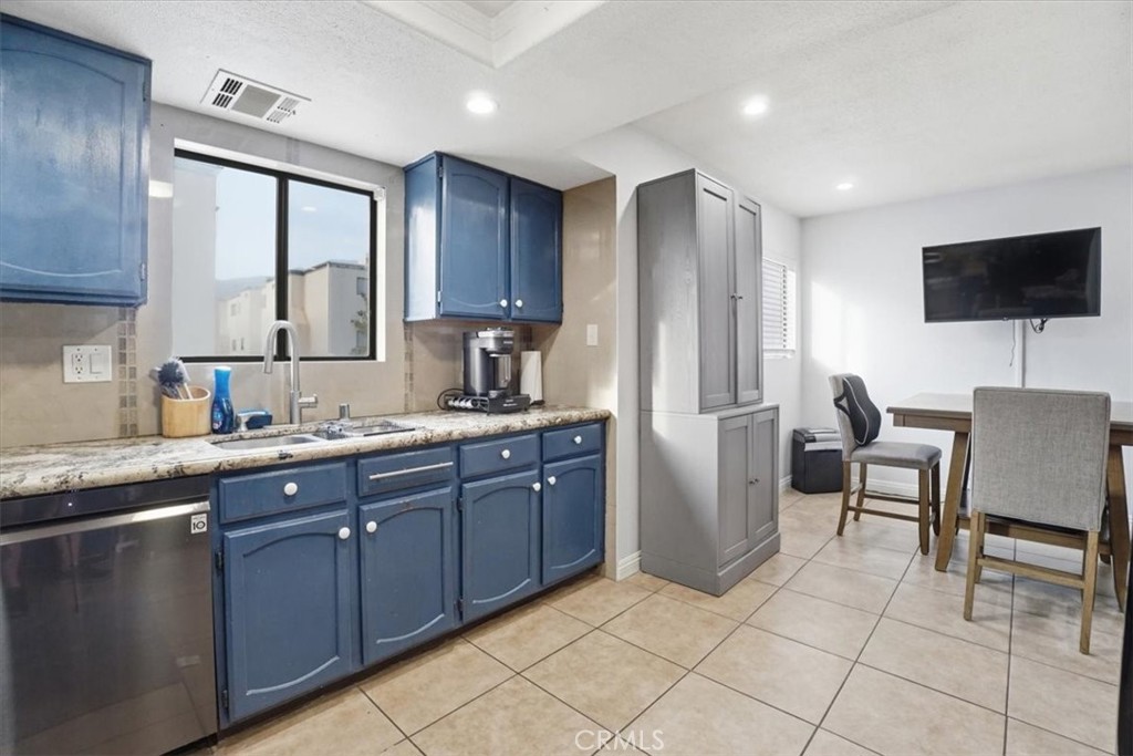 14325 Foothill Boulevard, Unit 9 Sylmar, CA 91342 - Photo 11 of 43 a kitchen with stainless steel appliances granite countertop a sink and a refrigerator