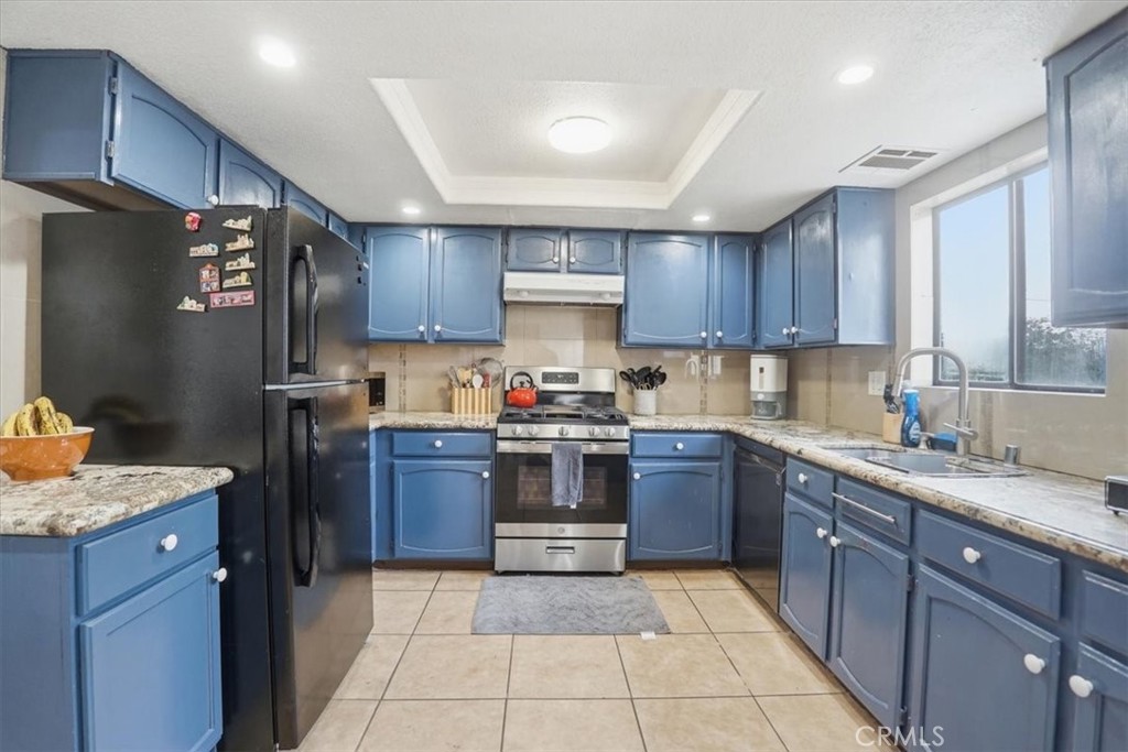 14325 Foothill Boulevard, Unit 9 Sylmar, CA 91342 - Photo 12 of 43 a kitchen with granite countertop wooden cabinets and stainless steel appliances