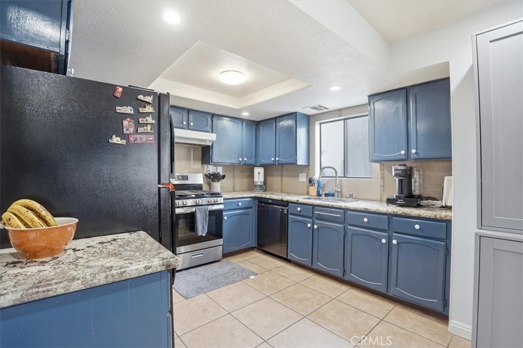 14325 Foothill Boulevard, Unit 9 Sylmar, CA 91342 - Photo 13 of 43 a kitchen with stainless steel appliances granite countertop a sink stove and refrigerator