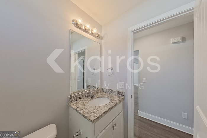 228 Western Red Cedar Drive Springfield, GA 31329 - Photo 13 of 27 a bathroom with a granite countertop sink a toilet and a mirror