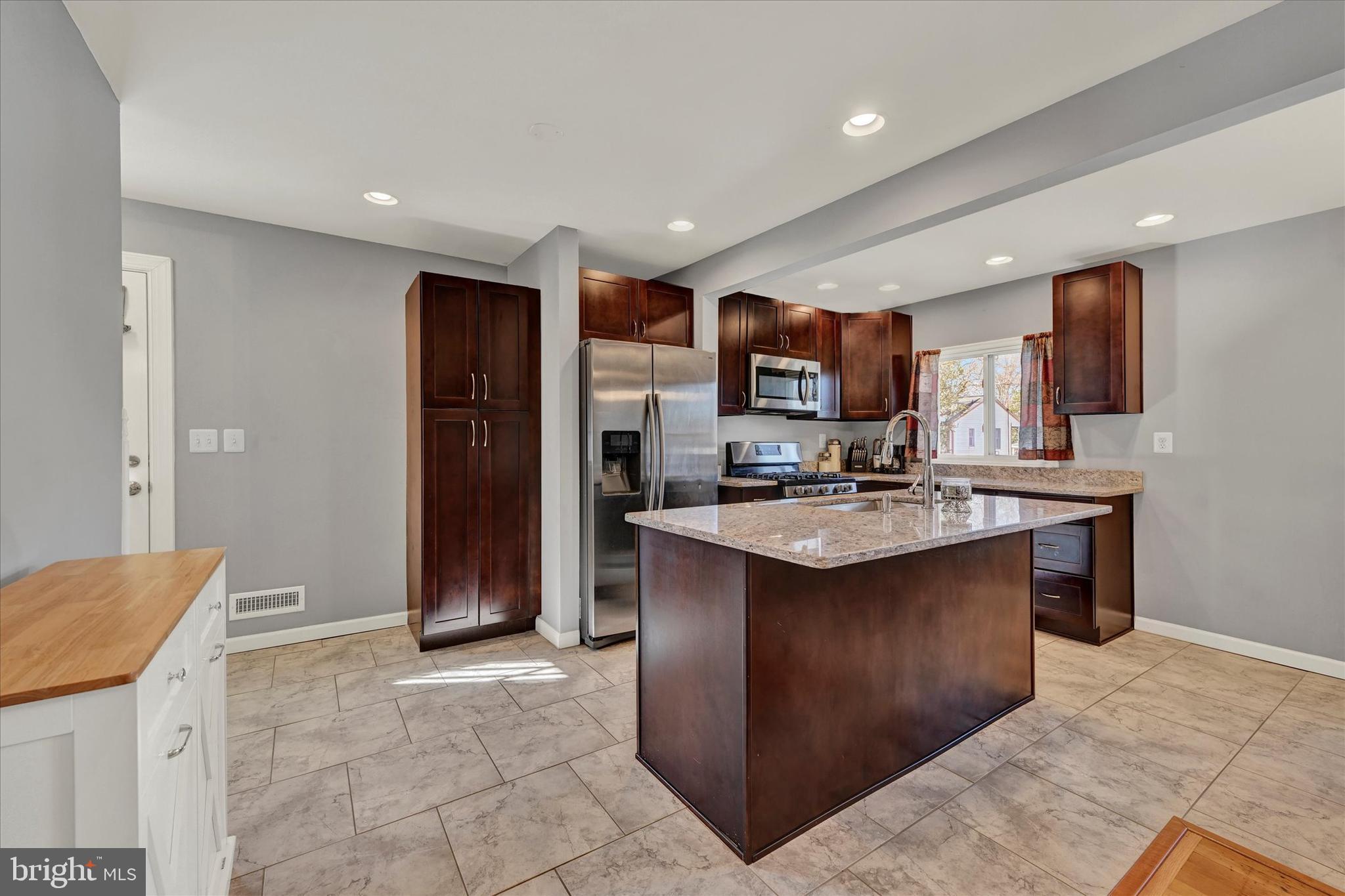 9630 10th Avenue Baltimore, MD 21234 - Photo 11 of 35 a kitchen with stainless steel appliances granite countertop a sink stove and refrigerator