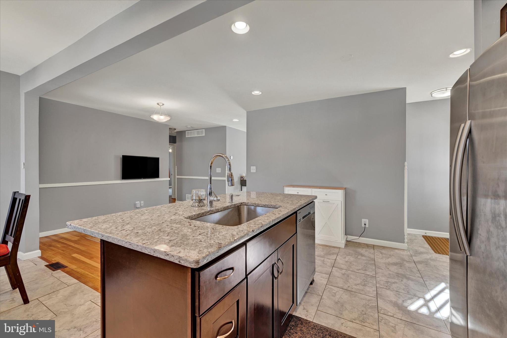 9630 10th Avenue Baltimore, MD 21234 - Photo 14 of 35 a bathroom with a granite countertop sink and a refrigerator