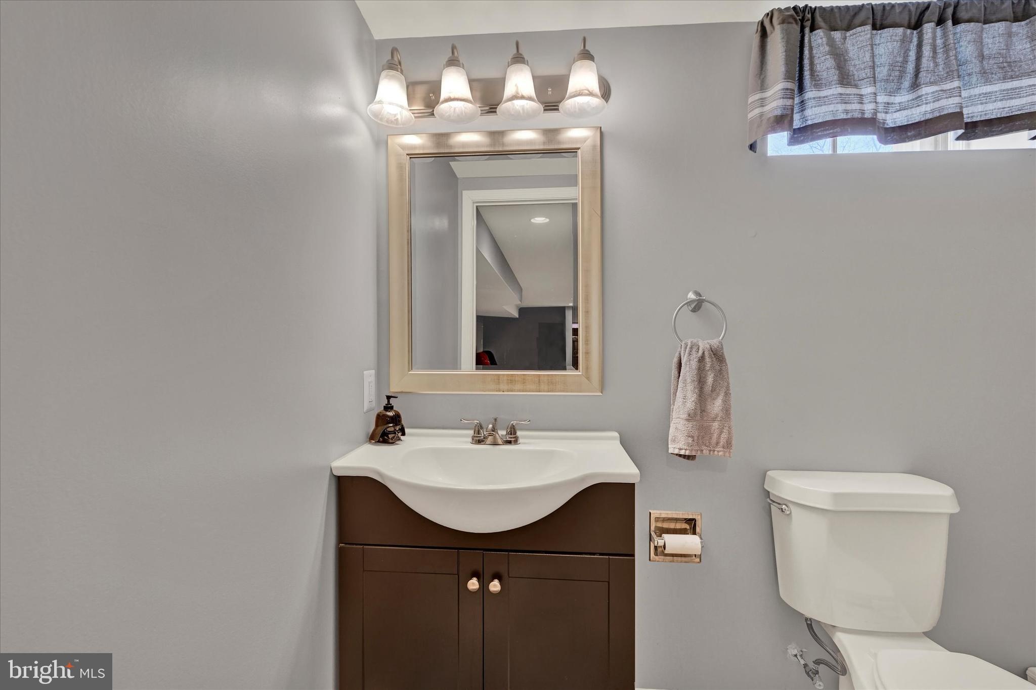 9630 10th Avenue Baltimore, MD 21234 - Photo 24 of 35 a bathroom with a toilet sink and mirror