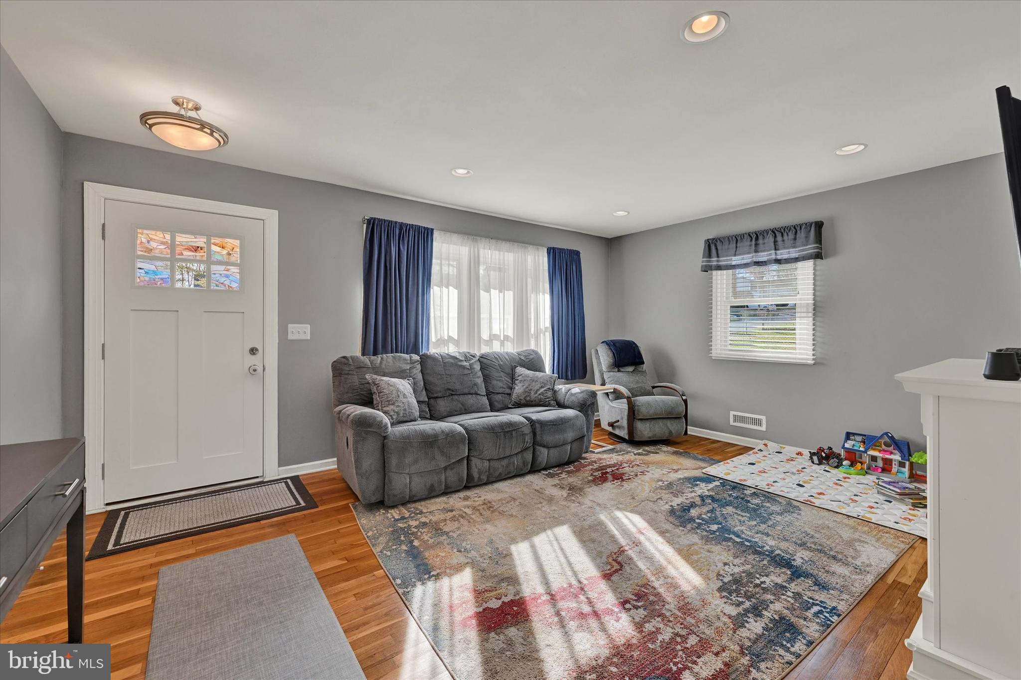 9630 10th Avenue Baltimore, MD 21234 - Photo 4 of 35 a living room with furniture a couch and dresser with wooden floor