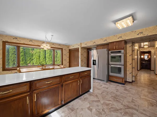 a large kitchen with kitchen island a sink stainless steel appliances and cabinets