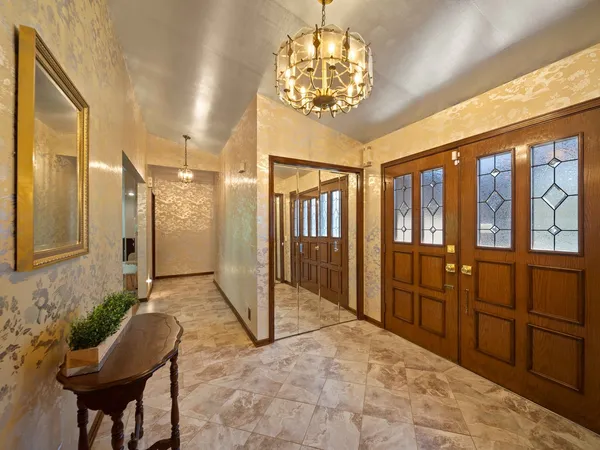 a view of a hallway with furniture and chandelier