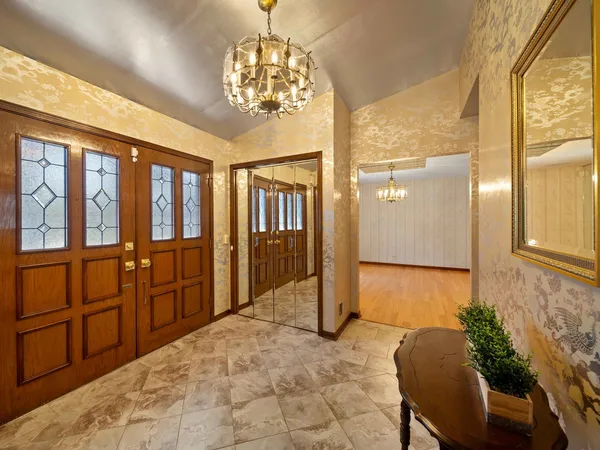 a view of a hallway with furniture and a chandelier