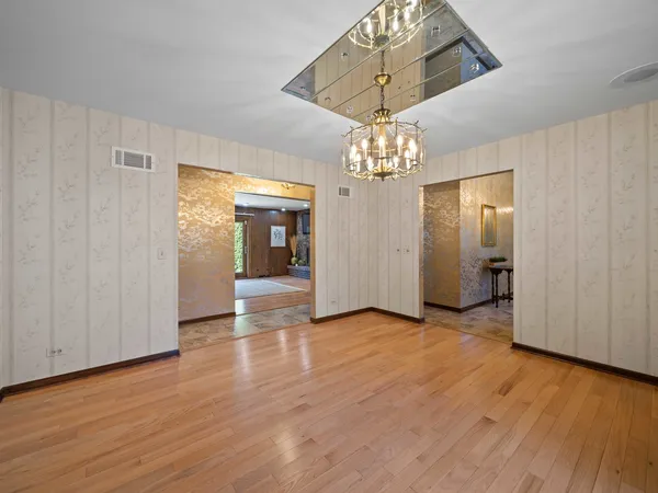 a view of a livingroom with a chandelier fan and windows