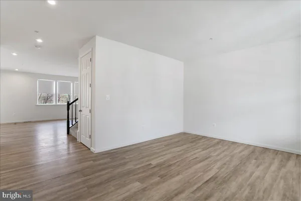 a view of empty room with wooden floor and windows