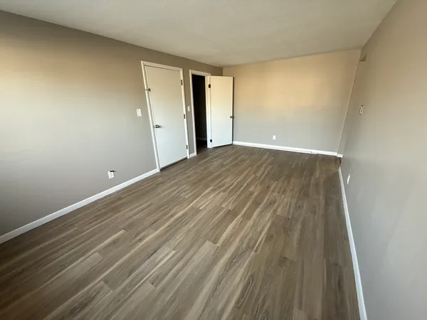a view of an empty room with wooden floor
