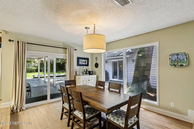 a dining room with wooden floor and a fireplace