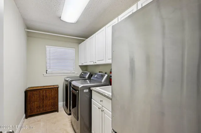 a kitchen with stainless steel appliances granite countertop a table chairs stove and refrigerator