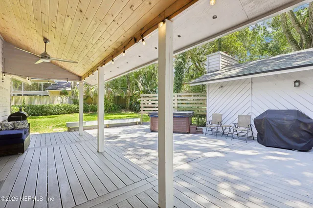 a view of a patio with table and chairs a barbeque with wooden floor and fence