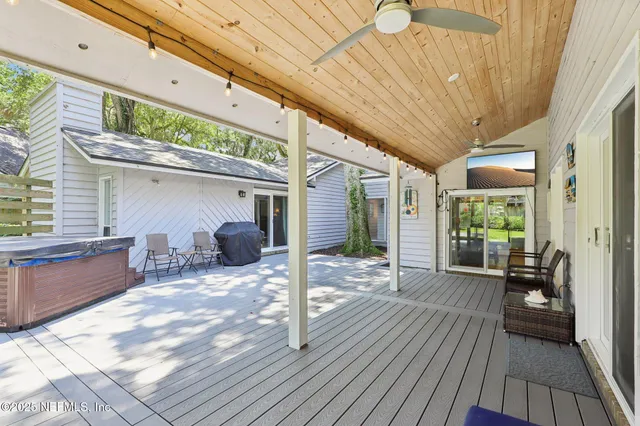 a view of a patio with table and chairs with wooden floor and fence
