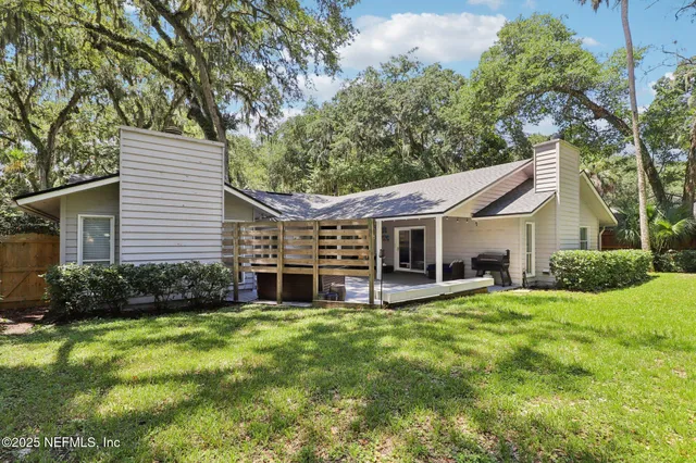 a view of a yard with plants and trees