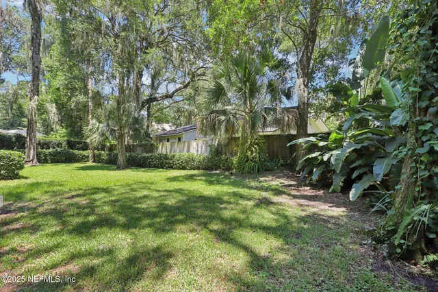 a view of backyard of house with green space