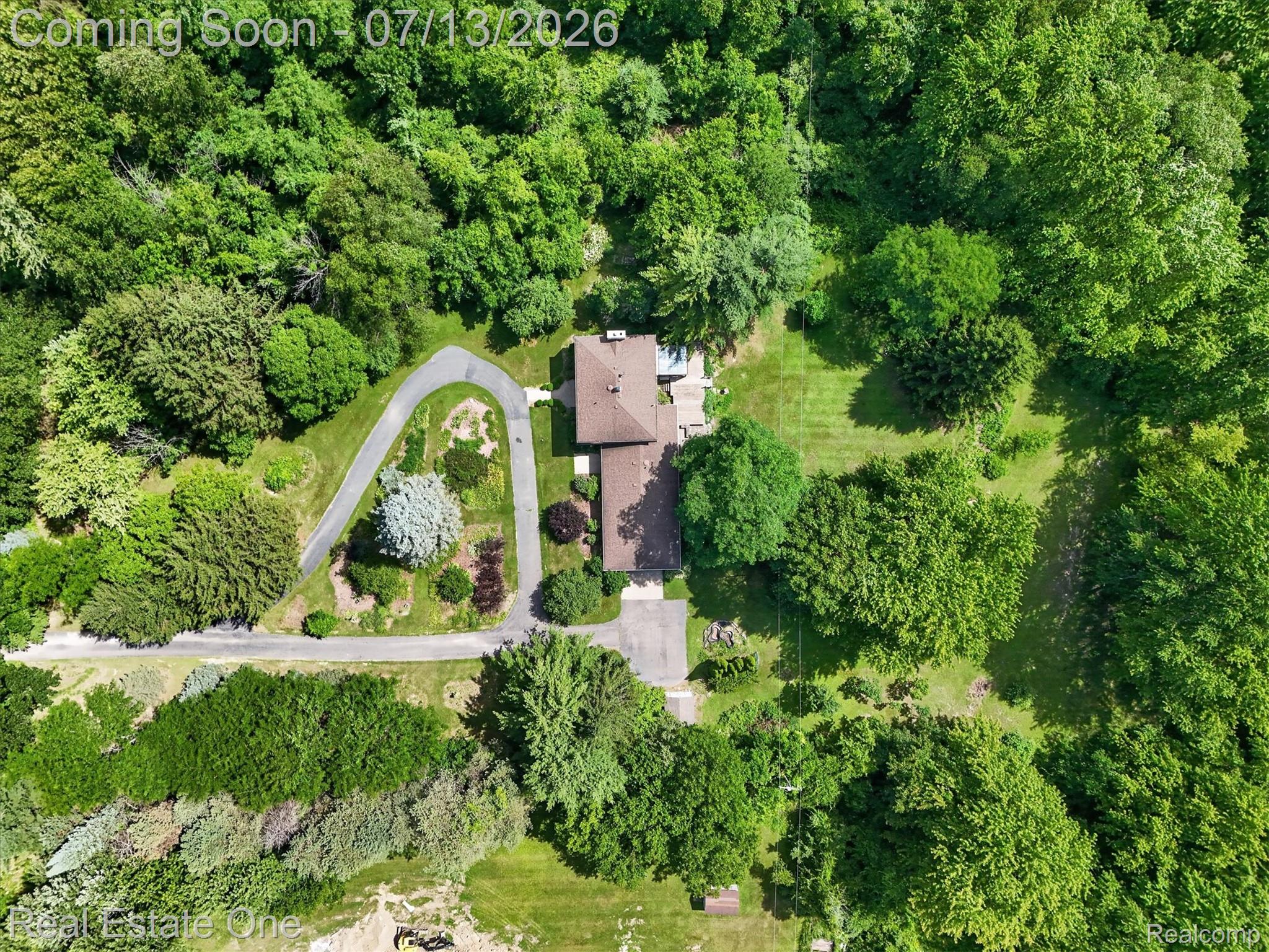 6039 Fish Lake Road Holly, MI 48442 - Photo 57 of 70 Expansive property featuring a brown-roofed residence, a winding paved driveway, mature trees, manicured lawns, and substantial green space