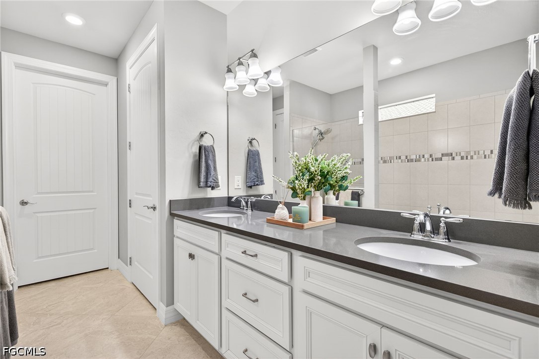 11932 Bourke Place Fort Myers, FL 33913 - Photo 21 of 44 a bathroom with double vanity sinks and a mirror