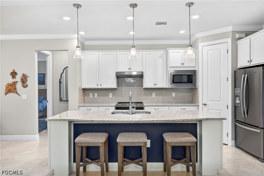 11932 Bourke Place Fort Myers, FL 33913 - Photo 3 of 44 a kitchen with kitchen island granite countertop a table chairs refrigerator and microwave
