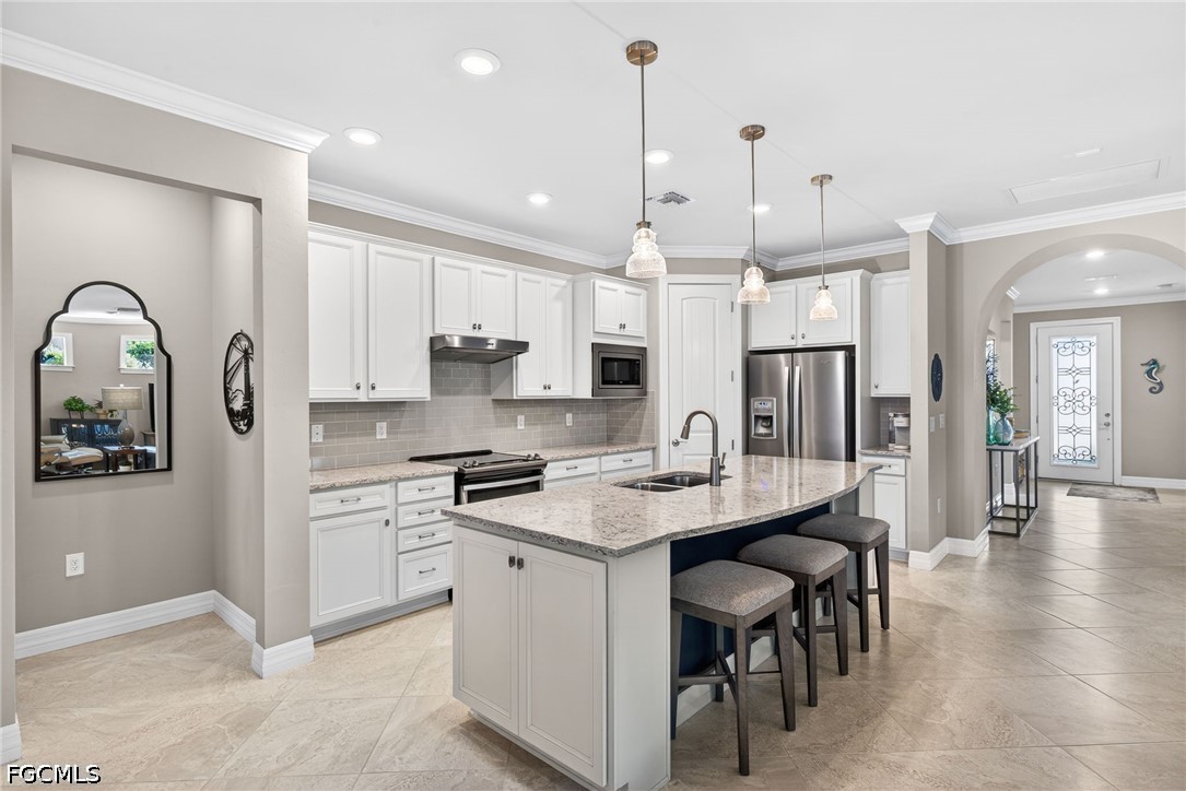 11932 Bourke Place Fort Myers, FL 33913 - Photo 8 of 44 a kitchen with stainless steel appliances kitchen island a table chairs refrigerator and microwave