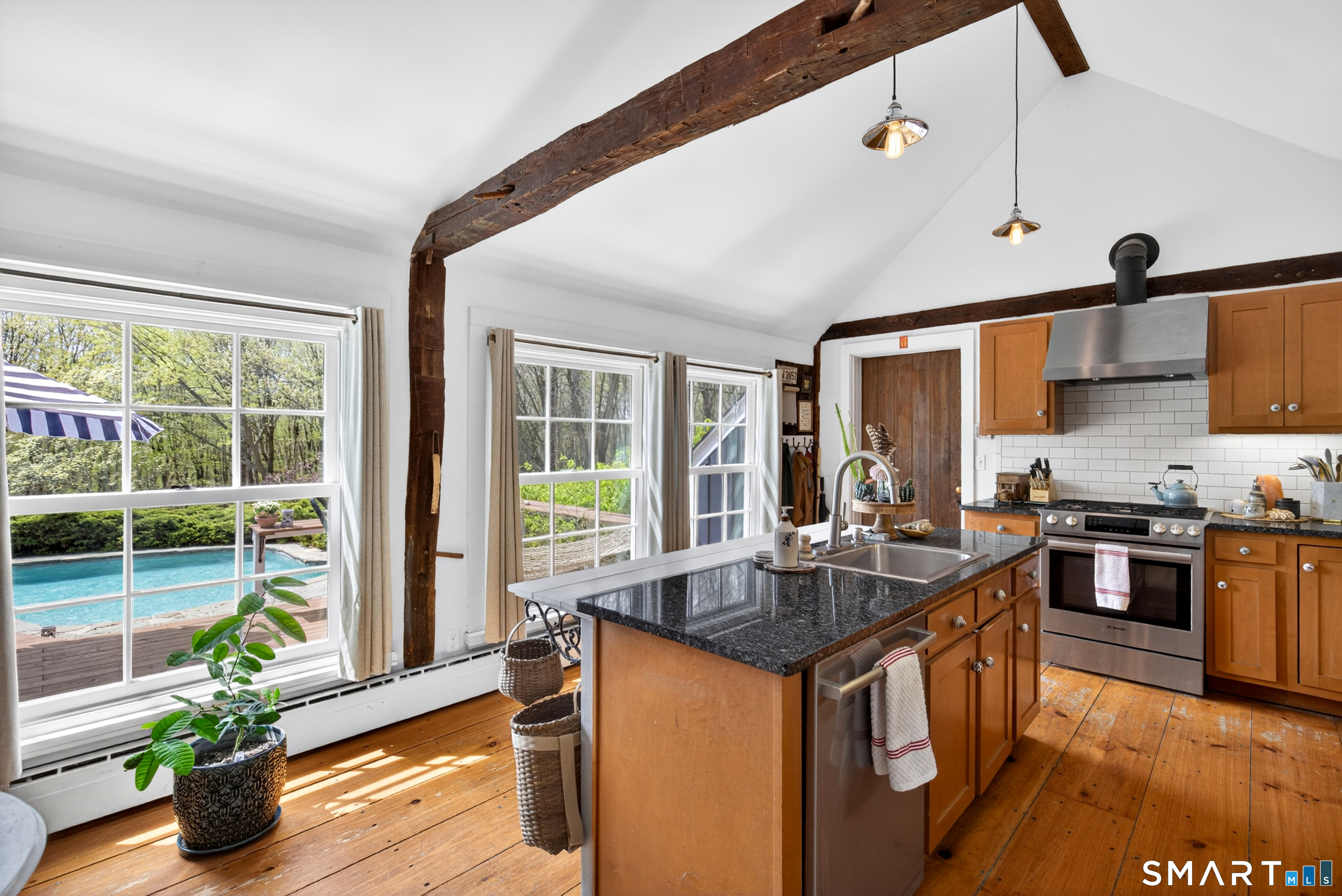 95 Chestnut Hill Road Killingworth, CT 06419 - Photo 17 of 40 Vaulted ceilings and exposed beams with a wall of windows in the kitchen.