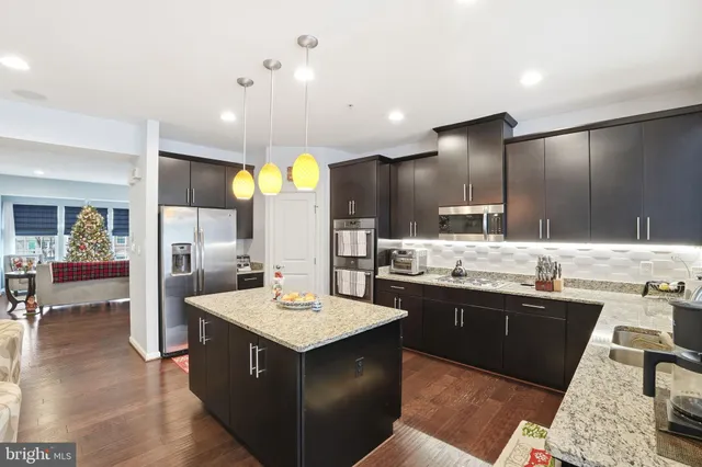 a large kitchen with a center island and stainless steel appliances