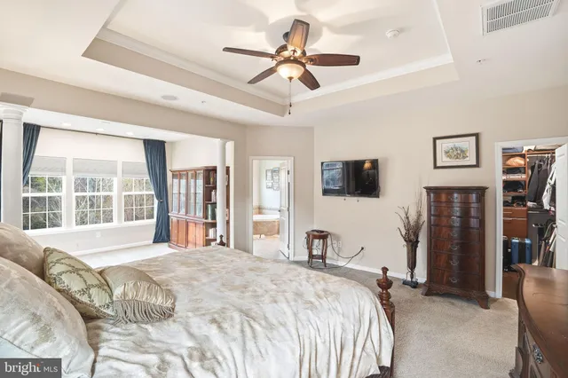 a bedroom with a bed flat screen tv and a large window