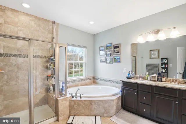 a spacious bathroom with a tub sink shower and mirror