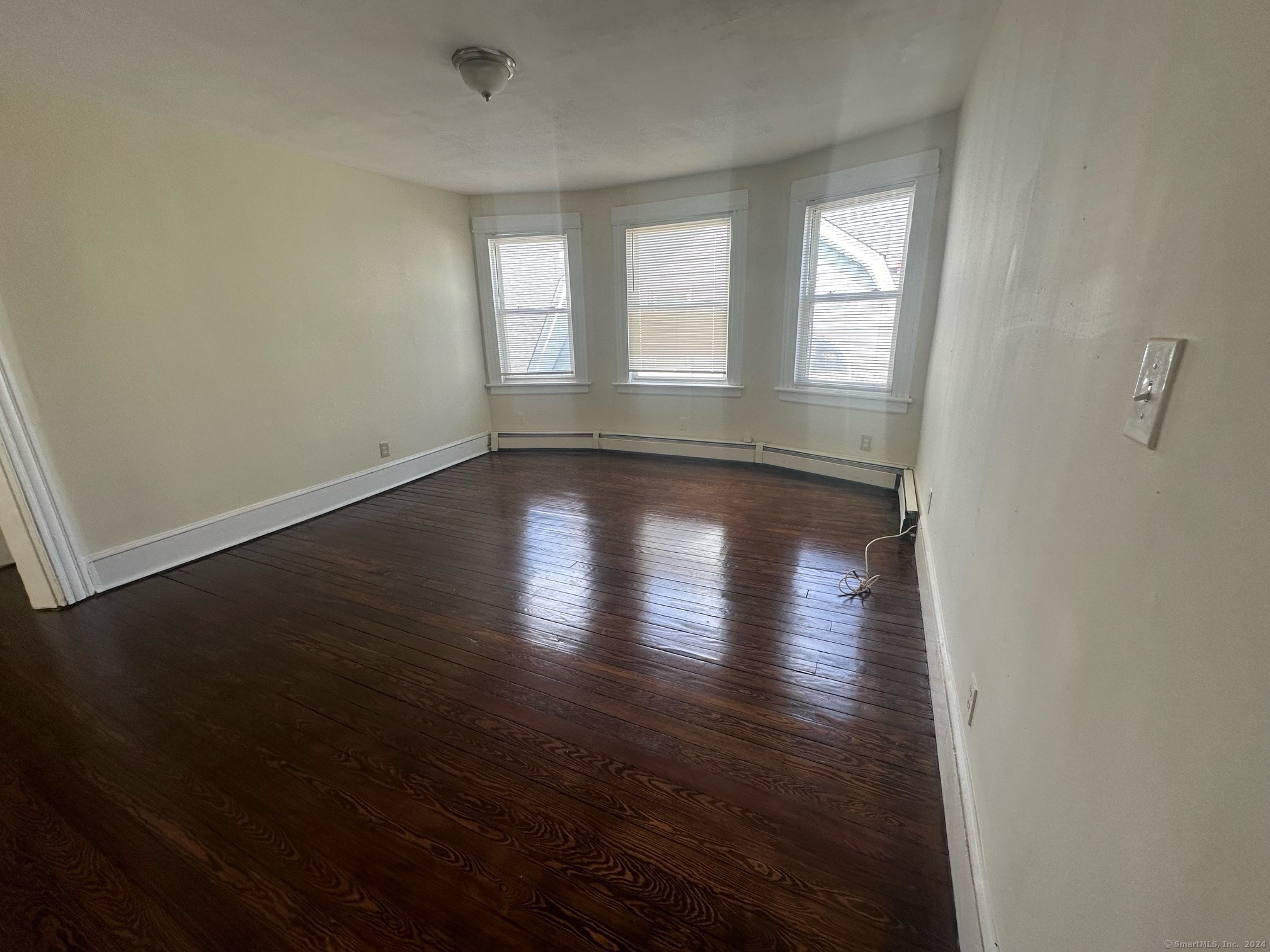 40 Vine Street, Unit 3 Bridgeport, CT 06604 - Photo 11 of 14 an empty room with wooden floor and windows