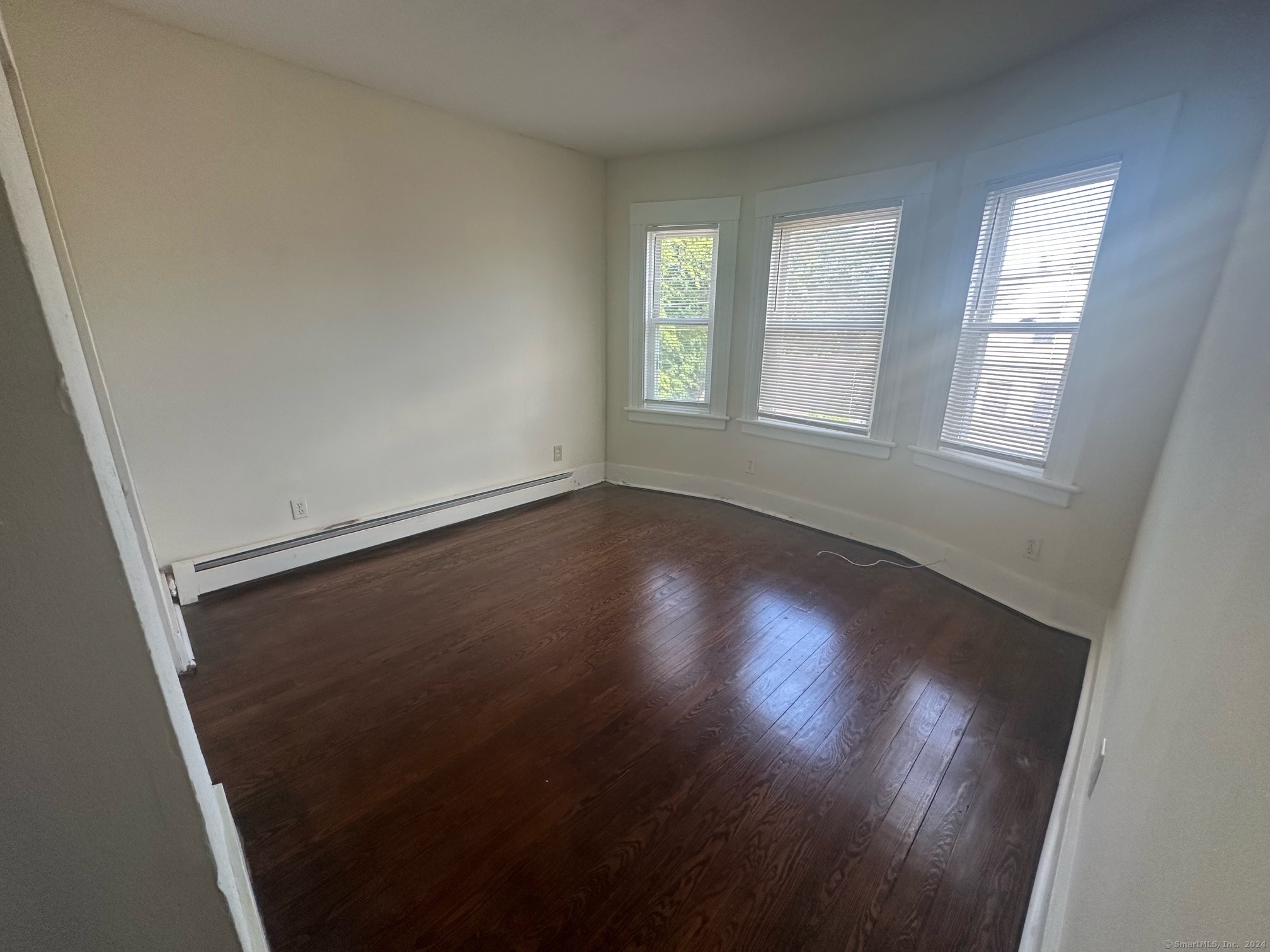 40 Vine Street, Unit 3 Bridgeport, CT 06604 - Photo 13 of 14 an empty room with wooden floor and windows