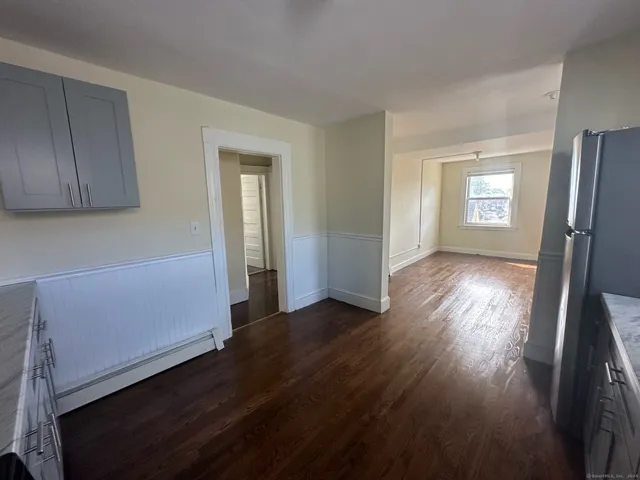 a view of a room with wooden floor and a window