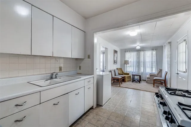 a kitchen with sink refrigerator and cabinets
