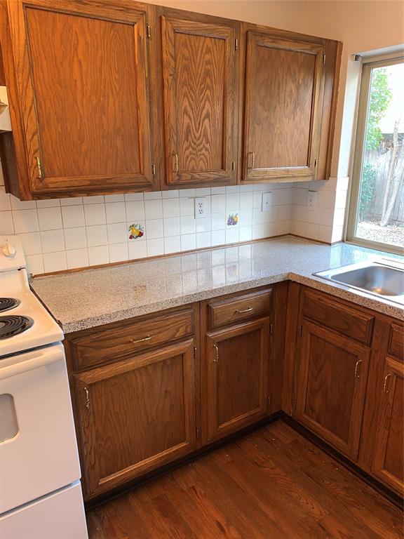 1605 Spanish Trail Plano, TX 75023 - Photo 2 of 5 a kitchen with granite countertop cabinets stainless steel appliances wooden floor and a window