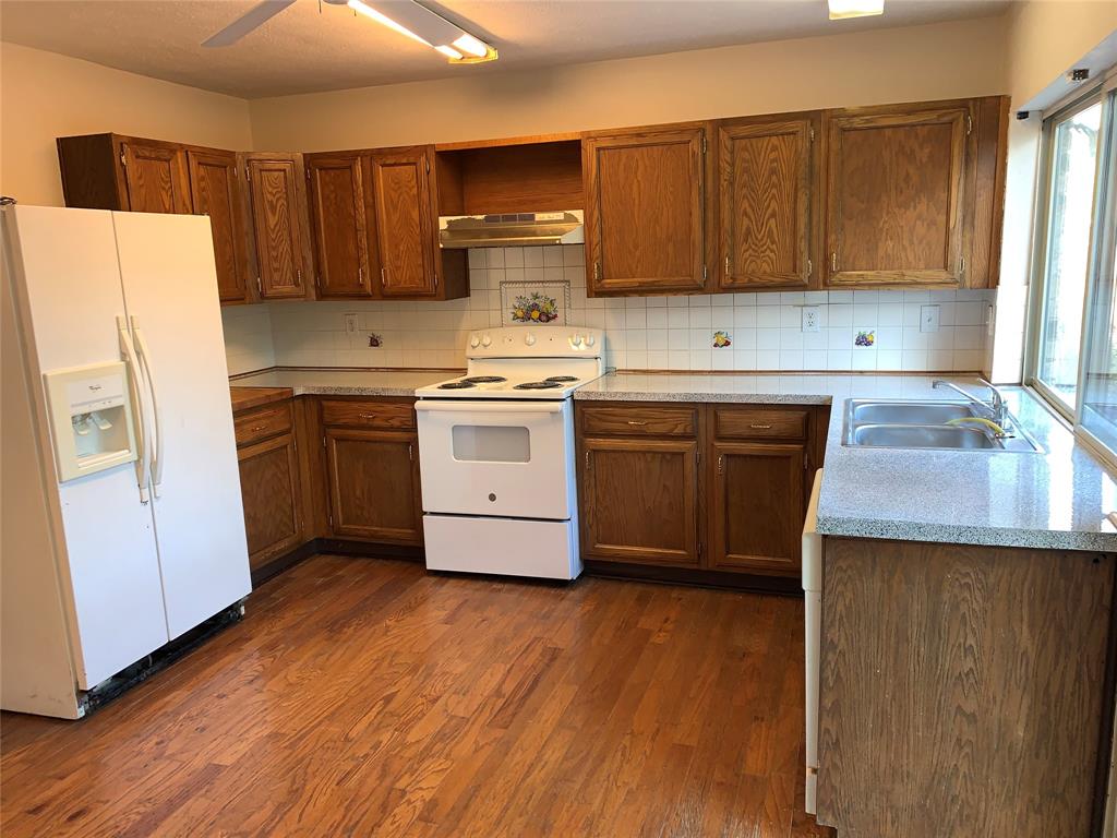1605 Spanish Trail Plano, TX 75023 - Photo 4 of 5 a kitchen with stainless steel appliances granite countertop a stove a sink dishwasher and a refrigerator