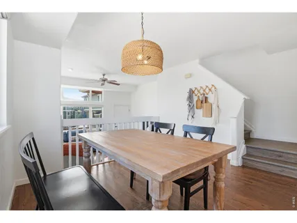a dining room with wooden floor a chandelier a wooden table and chairs