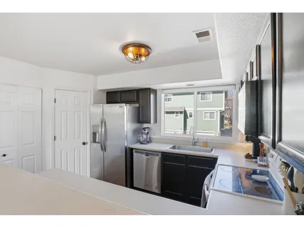 a kitchen with stainless steel appliances kitchen island granite countertop a sink a stove and refrigerator