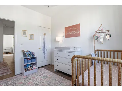 a view of a bedroom with baby crib and furniture