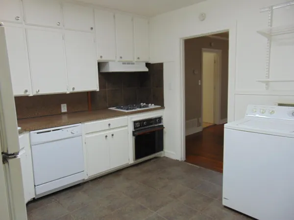 a kitchen with granite countertop white cabinets and white appliances