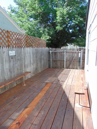 a view of backyard with green space and wooden fence