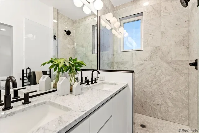 a bathroom with a granite countertop sink a mirror and shower