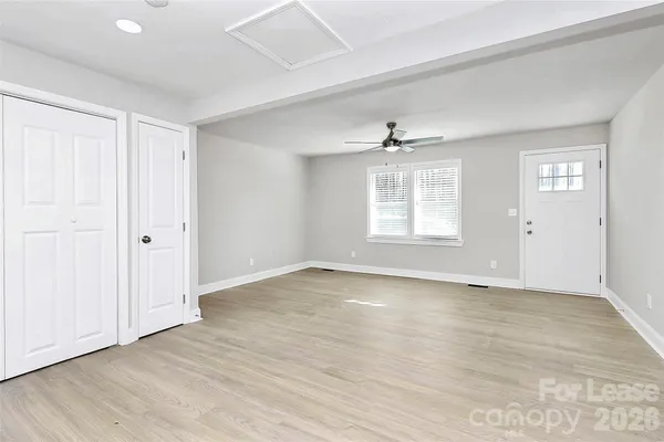 an empty room with wooden floor and windows
