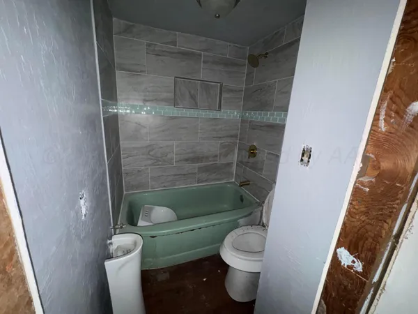 a bathroom with a shower a toilet and sink