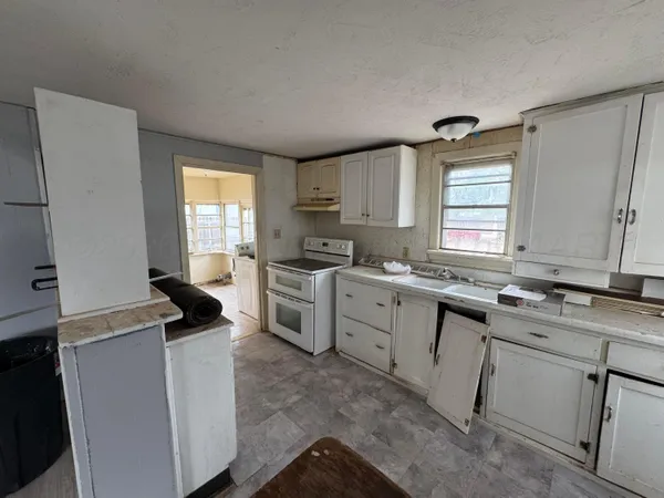 a kitchen with a stove a sink and a window