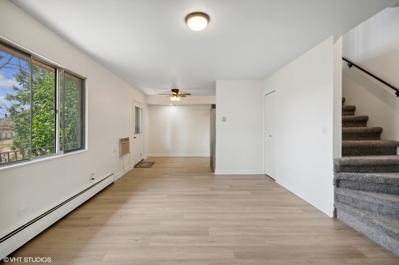 2300 West Algonquin Road, Unit 6 Rolling Meadows, IL 60008 - Photo 4 of 17 a view of an empty room with wooden floor and a window